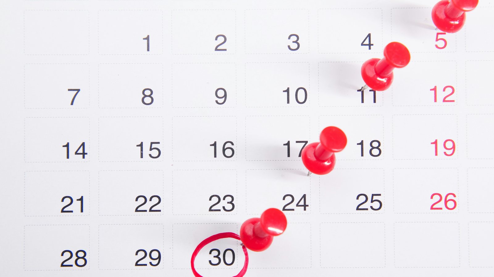 Kalender met rode punaises en een omcirkelde datum