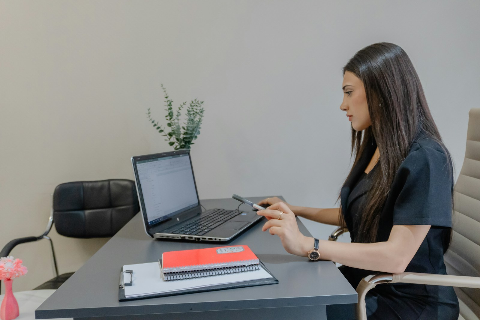 Woman working on a laptop at a desk.